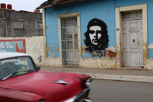 Kubareisen-Santa-Clara-Hauswand-mit-CheGuevara-rotes-Auto